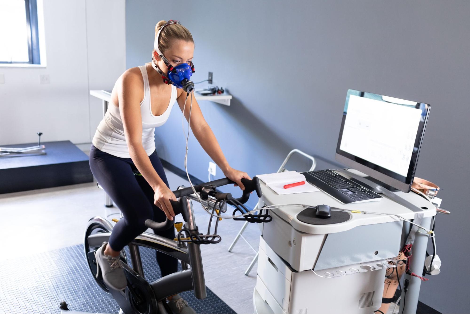 Žena provádí zátěžový test na cyklistickém ergometru